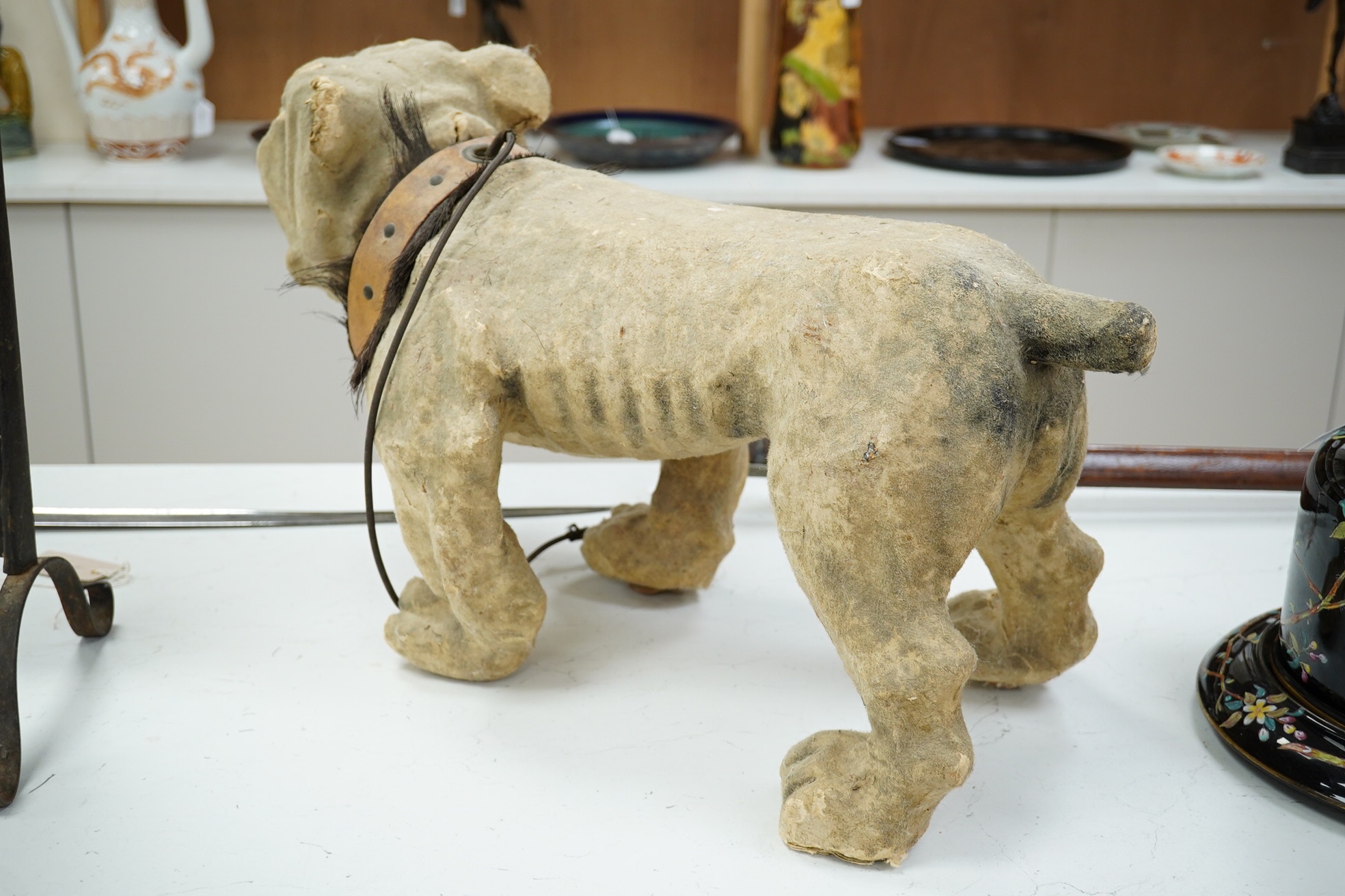 A French papier mache bulldog with bark effect, 66cm long, 35cm high. Condition - poor, some mis-shaping and part of muzzle, nose and ears missing